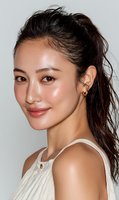 Young Asian woman with natural makeup and messy ponytail hairstyle wearing white sleeveless top, smiling confidently against neutral background.