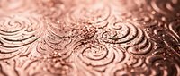 Elegant copper metallic surface with intricate embossed ornamental patterns and swirls creating luxurious decorative texture for premium design projects.