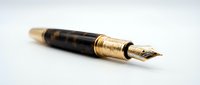 Luxury fountain pen with gold-plated trim and tortoiseshell barrel isolated on white background, suitable for stationery, writing, and office design projects.