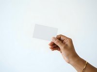 Hand holding blank white card against neutral background, suitable for business branding, marketing mockups, and promotional material design.