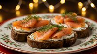 Smoked salmon canapes on dark bread with cream cheese and fresh dill garnish served on festive holiday plate with warm bokeh lights for Christmas celebration.