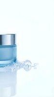 Glass jar with blue liquid and scattered ice cubes on white background, isolated for skincare, cosmetics, and beverage product design use.