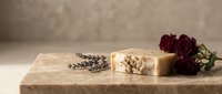 Handmade soap bars with lavender and rose petals on wooden surface for natural skincare, wellness, and spa product marketing.