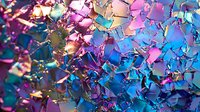 Vibrant shattered glass fragments in blue, pink, and purple tones creating abstract mosaic pattern with metallic iridescent reflections. Dynamic composition for backgrounds.