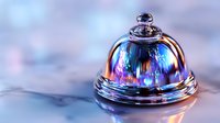 Shiny service bell with iridescent rainbow colors reflecting on metallic surface against blurred background, luxury hotel and hospitality concept.