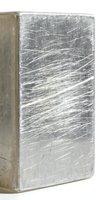Scratched silver metal block with worn textured surface showing industrial wear patterns and metallic finish for manufacturing concepts.