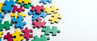 Colorful jigsaw puzzle pieces scattered on white background representing teamwork, problem solving and business strategy concepts for presentations.