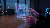 Businessman using futuristic holographic tablet with digital interface displaying data analytics in modern office environment at night.