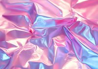 Crumpled holographic fabric with pink and blue iridescent metallic surface creates abstract texture background with shiny wrinkles and folds.
