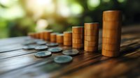 Wooden game pieces and silver coins arranged in ascending order on rustic wooden surface with blurred natural background.