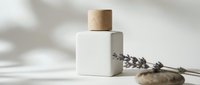 Minimalist white square cosmetic bottle with wooden cap, lavender sprig and stones on light background, natural skincare product presentation.