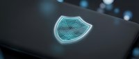 Glowing neon shield icon on dark surface with bokeh lights, representing cybersecurity, data protection, and digital safety for technology and security applications.