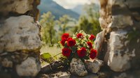 Red flowers blooming through ancient stone wall ruins with mountain landscape background. Nature reclaiming historical architecture concept.