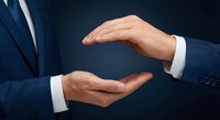 Businessman hands in protective gesture showing care and security concept for insurance coverage and risk management in corporate environment.
