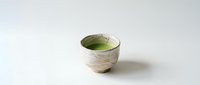 Matcha tea in rustic ceramic bowl on white background, isolated for beverage, wellness, and Japanese culture design projects.