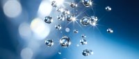 Sparkling diamonds floating in blue light with bright bokeh effects creating luxury jewelry background for premium advertising and elegant design projects.