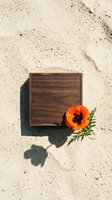 Wooden box with orange flower on sandy beach background for natural product packaging and eco-friendly branding concepts.