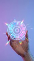 Hand holding glowing neon circular dial wheel with cyan and pink light rays against purple gradient background for technology and innovation concepts.