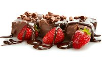 Fresh strawberries with dark chocolate curls and drizzle on white background, sweet dessert composition for confectionery and food design.