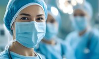 Female medical professional wearing surgical mask and cap in hospital operating room with blurred colleagues in background, healthcare concept.