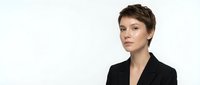 Professional businesswoman with short brown hair in black blazer on white background for corporate presentations and marketing materials.