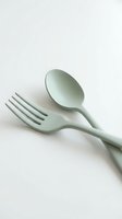 Sage green fork and spoon cutlery set on white background for kitchen dining and restaurant use.
