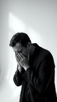 Middle-aged Caucasian businessman covering face with hands in despair, black and white portrait showing stress, depression, and emotional breakdown.
