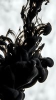 Black ink dissolving in water, creating dramatic swirling cloud shapes on light background, capturing fluid motion and abstract art.
