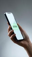 Hand holding a smartphone with a glowing green buy now button on screen, representing mobile shopping and e-commerce concepts.