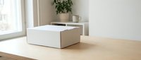 White cardboard box on a wooden table in a bright modern interior, soft natural light, minimalist home setting, packaging and delivery concept.