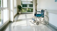 Empty wheelchair in bright hospital corridor with large windows and natural light streaming across polished floors for healthcare accessibility concepts.