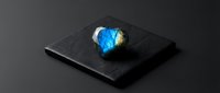 Miniature Earth globe emerging from open laptop screen on dark surface representing global connectivity and digital world access for business presentations.
