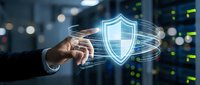 Businessman hand touching glowing digital shield icon with circular data streams representing cybersecurity protection and network defense technology.