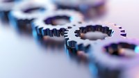 Metal gears with selective focus creating abstract industrial composition in blue tones, showing mechanical parts and engineering concept.