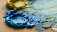 Close-up of vibrant blue and yellow oil paint strokes on canvas with thick impasto texture creating abstract artistic composition for creative projects.