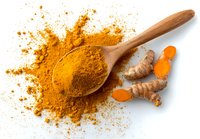 Turmeric powder in wooden spoon with fresh root pieces on white background, vibrant yellow spice for cooking and health benefits.