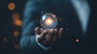 Glowing digital sphere with network connections floating above business person's palm against dark background with bokeh lights, representing global technology.