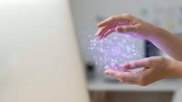 Person holding glowing purple digital sphere with neural network pattern, representing artificial intelligence, technology innovation, and futuristic data processing concepts.
