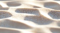 Smooth waves of golden sand create abstract natural pattern with soft shadows and light, macro close-up view showing detailed texture and gentle curves.