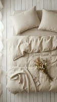 Natural linen bedding set with dried flowers on white wooden floor, cozy bedroom interior design for home decor and textile marketing materials.