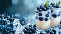 Fresh blueberry cocktail with ice cubes and rosemary garnish on dark background with bokeh lights, refreshing summer drink close up.