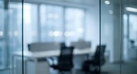 Blurred modern office meeting room with glass walls and conference table for business presentations and corporate environments.
