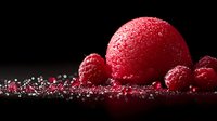 Red raspberry sorbet scoop with fresh raspberries and sugar crystals on dark background, dramatic food photography with selective lighting and sparkle effect.