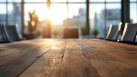 Empty modern conference room with wooden table at sunset, city skyline visible through large windows, professional business environment.
