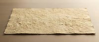 Textured beige stone slab with rough natural surface finish for construction and architectural design projects on neutral background.