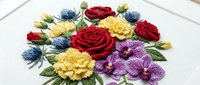 Colorful embroidered flowers including red roses, yellow dahlias, purple blooms and blue thistles on white fabric background. Ideal for textile art and craft projects.