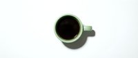 Green coffee mug with black coffee on white background, isolated for design projects and commercial use.
