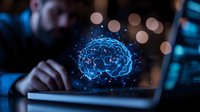 Glowing blue brain hologram floating above laptop keyboard with bokeh lights in dark office setting, representing artificial intelligence and cognitive technology.