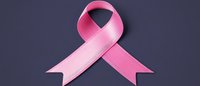 Pink awareness ribbon symbol on dark background, representing breast cancer support and solidarity in healthcare awareness campaigns and advocacy.