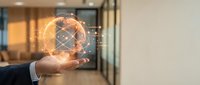 Businessman hand holding glowing digital globe with network connections in modern office environment for technology and global business concepts.